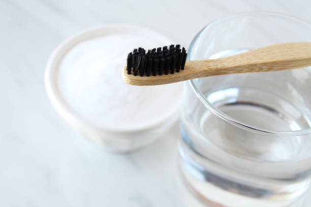 Bamboo toothbrush resting on water glass.